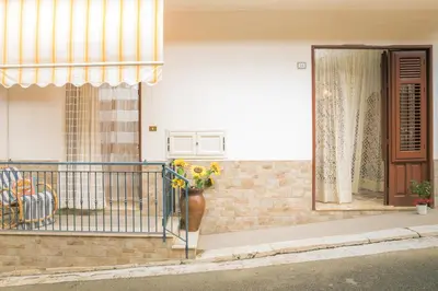 a vase of flowers on the balcony of a house at Casa Dorotea in Balestrate