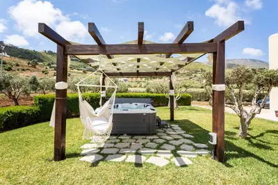 a gazebo with a hot tub and a swing at Villa delle Stelle in Scopello