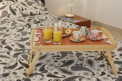 a tray with two glasses of orange juice on a bed at Villa delle Stelle in Scopello
