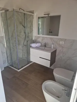 a bathroom with a shower and a sink and a toilet at Il Cavaliere Apartment in Capaci