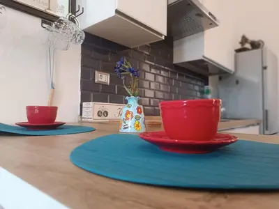 two red cups and saucers on a kitchen counter at Metro 171 Loft in Palermo