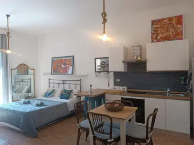 a bedroom with a bed and a kitchen with a table at Metro 171 Loft in Palermo