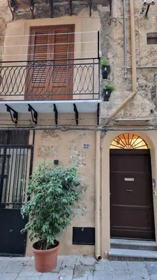 a building with two doors and a balcony and a plant at Casa Novelli 22 - Vista sulla Cattedrale in Palermo