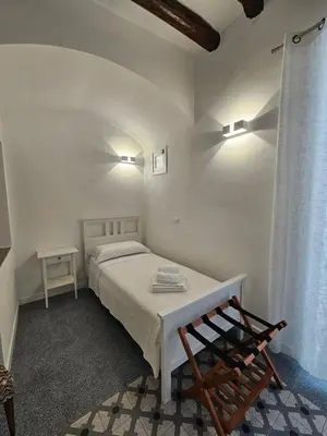 a white bedroom with a bed and a chair at Casa Novelli 22 - Vista sulla Cattedrale in Palermo