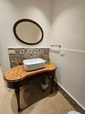 a bathroom with a sink and a mirror on a table at Casa Novelli 22 - Vista sulla Cattedrale in Palermo