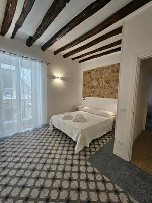 a bedroom with a bed and a brick wall at Casa Novelli 22 - Vista sulla Cattedrale in Palermo