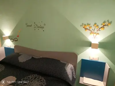 a bedroom with a bed with a sign on the wall at Aura's Apartment in Palermo