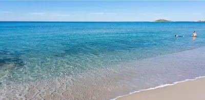 two people swimming in the water at the beach at Aura's Apartment in Palermo