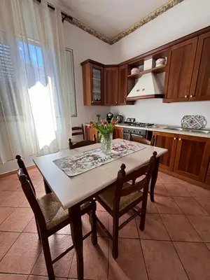 a kitchen with wooden cabinets and a table with bananas on the counter at Girasole in Palermo