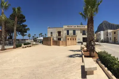 a building with a palm tree in front of it at Coralìa in San Vito lo Capo
