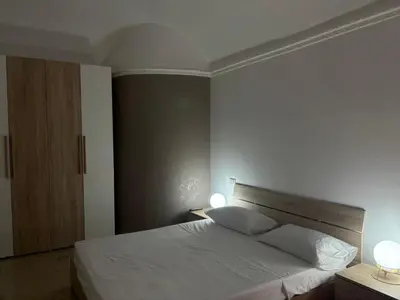 a bedroom with a white bed with two lamps at Appartamento San Vito in Piana degli Albanesi