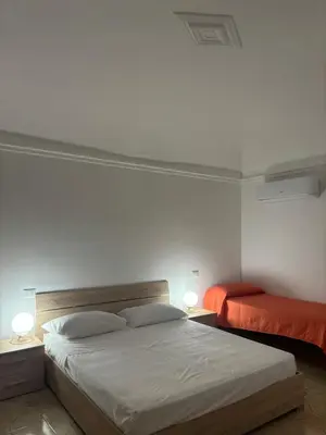 a bedroom with two beds and two lamps in it at Appartamento San Vito in Piana degli Albanesi