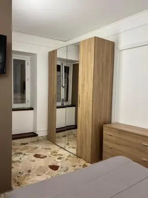 a bedroom with a mirror and a wooden cabinet at Appartamento San Vito in Piana degli Albanesi