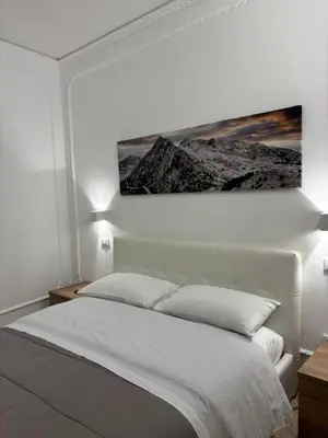 a bedroom with a white bed with a picture above it at Appartamento San Vito in Piana degli Albanesi