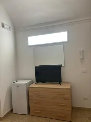 a room with a tv on top of a wooden dresser at Appartamento San Vito in Piana degli Albanesi