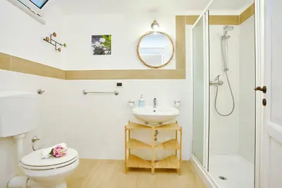 a bathroom with a toilet and a sink and a shower at Villa Lo Zingaro - Scopello-Villas in Scopello