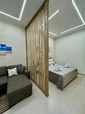 a bedroom with a bed and a couch at Casetta Philia - Castellammare del Golfo in Castellammare del Golfo