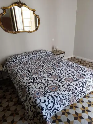 a bed in a bedroom with a mirror on the wall at La dimora del MARCHESE NOTARBARTOLO in Palermo