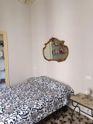 a bedroom with a bed and a mirror on the wall at La dimora del MARCHESE NOTARBARTOLO in Palermo