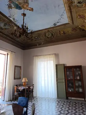 a living room with a table and a ceiling at La dimora del MARCHESE NOTARBARTOLO in Palermo