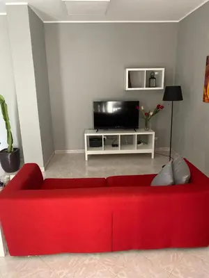 a red couch in a living room with a tv at Giuse home in Palermo