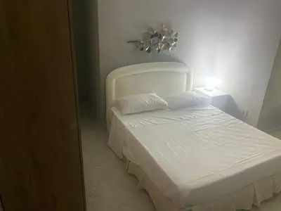 a small bedroom with a white bed and a lamp at Giuse home in Palermo