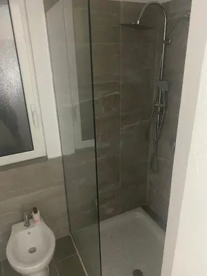 a bathroom with a shower with a toilet and a sink at Giuse home in Palermo