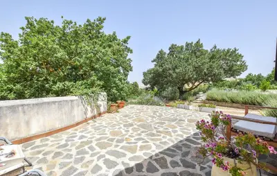 a stone walkway with trees and benches in a garden at Pet Friendly Home In Corleone With Wifi in Corleone