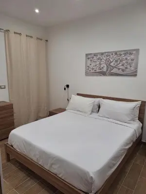 a bedroom with a large bed with white sheets at Casa Sabo Apartment in Palermo