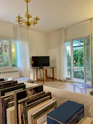 a living room with a pile of books and a tv at Splendida Villa immersa nella natura - Villa Salina Trabia in Trabia