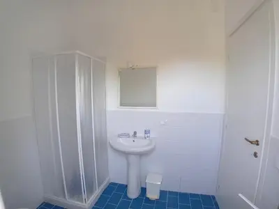 a white bathroom with a sink and a shower at ai colori di Giggia in Isola delle Femmine
