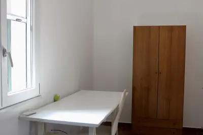a bed with white sheets and a picture on the wall at Gli ulivi di Cala Rossa By Dimora Hub in Terrasini