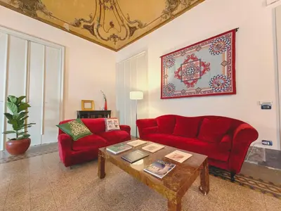 a living room with a red couch and a coffee table at Centro storico-Marina Free Parking, Wifi,Netflix in Palermo