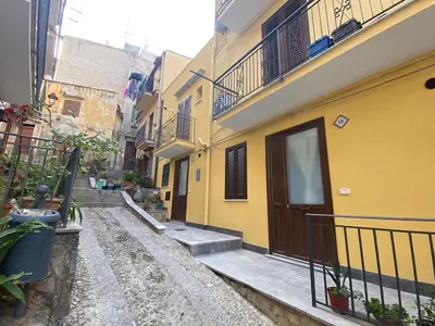 an alley with stairs and a yellow building at Casa Vacanze dell'Arco - civico 17 in Trabia