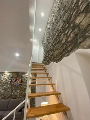 a staircase in a house with a large rock on the ceiling at Casa Vacanze dell'Arco - civico 17 in Trabia