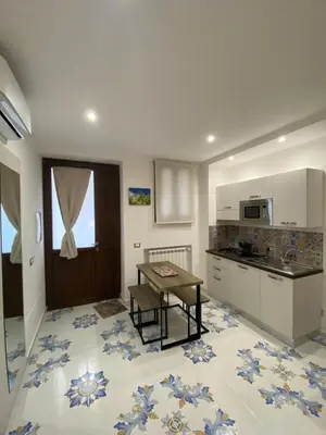 a kitchen with a table and a counter top at Casa Vacanze dell'Arco - civico 17 in Trabia