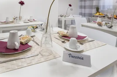 a white table with a plate of food on it at Due Passi in Palermo