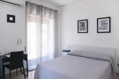 a bedroom with a bed and a desk and a window at Due Passi in Palermo