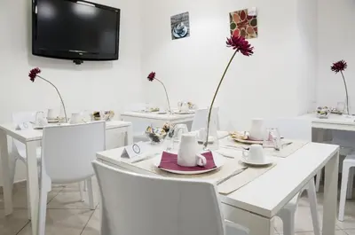 a white dining room with a white table and white chairs at Due Passi in Palermo
