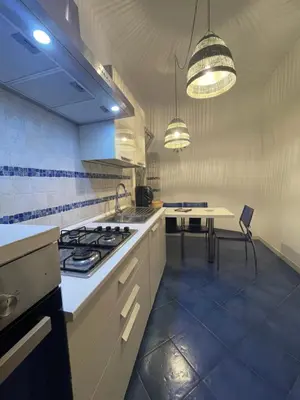 a kitchen with a stove and a table in it at Hola House Mondello in Lido di Mondello