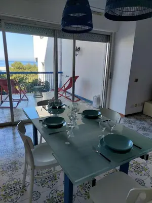 a table with plates and glasses on top of it at Hola House Mondello in Lido di Mondello