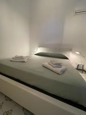 a bedroom with a bed with two towels on it at Hola House Mondello in Lido di Mondello