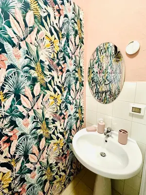 a bathroom with a sink and a tropical wallpaper at Casa Lilla in Monreale