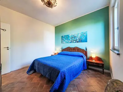 a bedroom with a bed with a blue comforter at Villa Ginestra by Interhome in Piana degli Albanesi