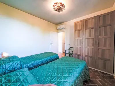 a bedroom with two beds and a chandelier at Villa Ginestra by Interhome in Piana degli Albanesi
