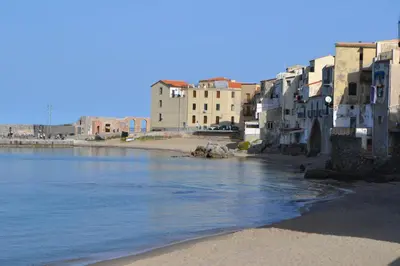 a group of buildings on a beach next to the water at Nichi & Matti Iemmolo's Guest House in Campofelice di Roccella