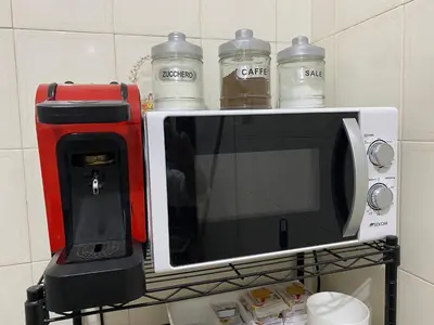 a coffee maker and a microwave on a shelf at Nichi & Matti Iemmolo's Guest House in Campofelice di Roccella