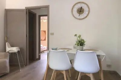 a dining room with a table and two white chairs at Nichi & Matti Iemmolo's Guest House in Campofelice di Roccella