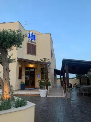 a building with a sign on the side of it at Residence Hotel Marino Tourist in San Vito lo Capo