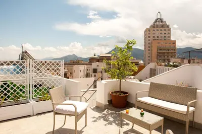 a balcony with chairs and a view of a city at La Terrazza su Palermo in Palermo